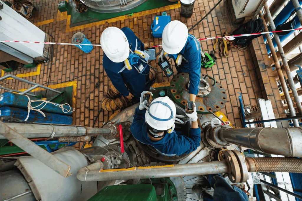 Tre operatori effettuano la prova di tenuta di una cisterna interrata